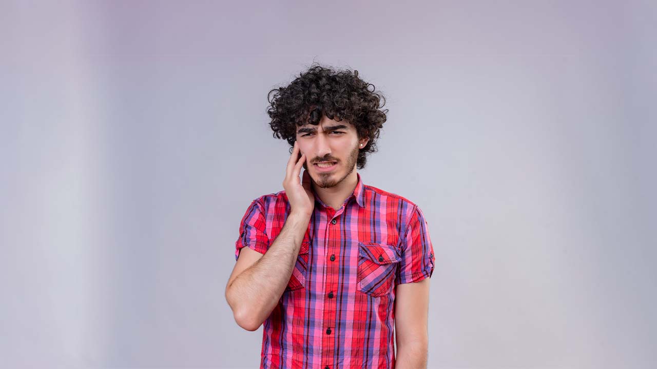 A young man with pain in his right tooth