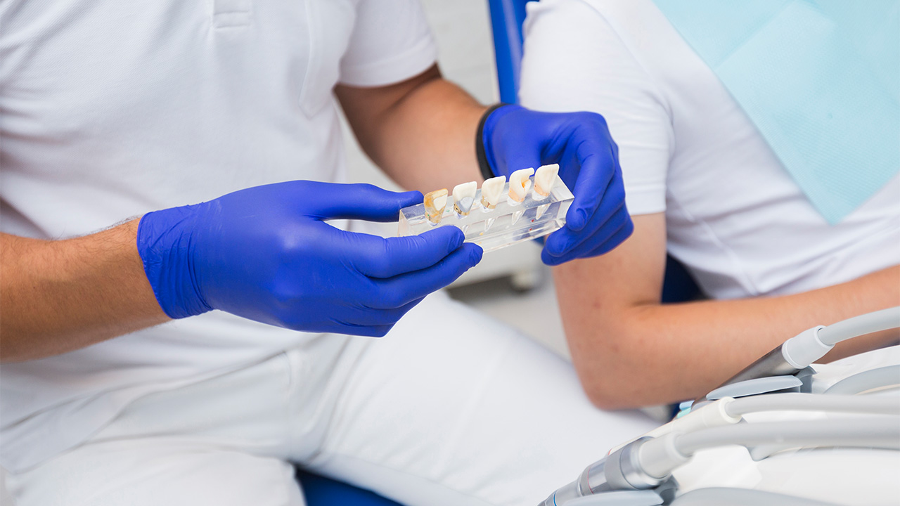 A dentist with several dental prostheses