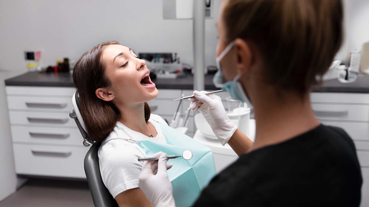 Young man with his mouth open while the doctor checks his teeth